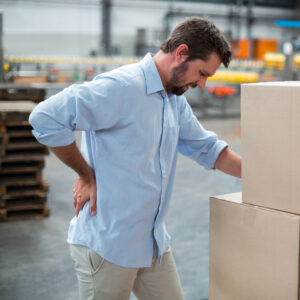 Tensed male worker standing with back pain